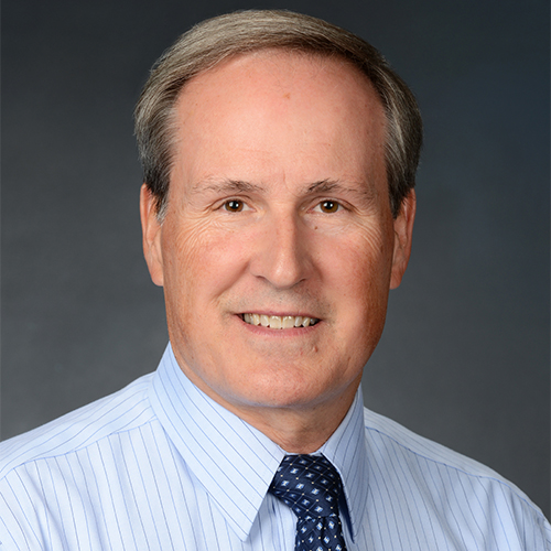 headshot of light-haired person in dress shirt and tie