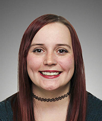 headshot of smiling person wearing choker